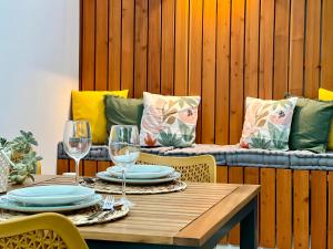 a table with plates and wine glasses and a couch at Domus Vallis - Modern house in Furnas in Furnas