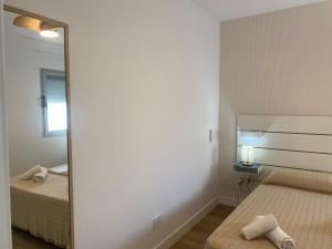 een slaapkamer met 2 bedden en een grote spiegel bij El Rincón de Valentina 4B in Las Palmas de Gran Canaria