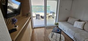 a living room with a couch and a flat screen tv at Apartman Lookman Neum in Neum