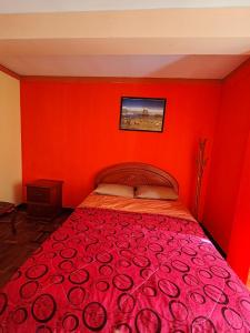 - une chambre rouge avec un lit avec un mur rouge dans l'établissement Yati Hostal, à La Paz