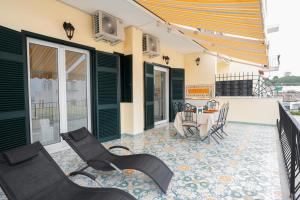 a patio with chairs and a table on a balcony at Ammore Ammare Apartment in Ischia Town