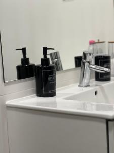 un lavabo con una botella de jabón y un espejo en Domus Vallis en Furnas