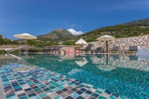 a swimming pool with chairs and umbrellas at Grey House in Bol