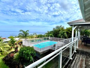 a balcony with a swimming pool on a house at Villa Tropical Quintet in Deshaies