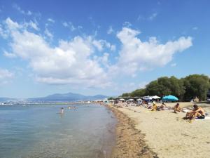 a group of people sitting on the beach at Ameli House in Neoi Epivates