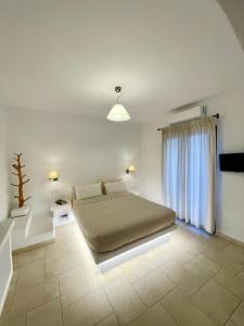 um quarto com uma cama e uma grande janela em Anemonisia Deluxe Apartments em Skiros