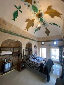 馬爾丁的住宿－ROYAL HİSTORY HOTEL & RESORT，一间卧室配有一张铺着落叶的床铺,天花板上涂有落叶画