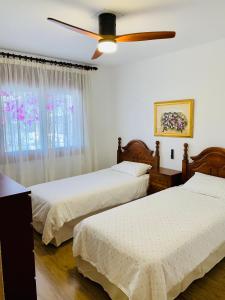 a bedroom with two beds and a ceiling fan at LA BARRACA - Ideal para familias y adultos responsables en busca de tranquilidad no se permiten fiestas in Mojácar