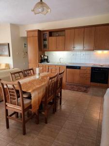 a kitchen with a wooden table and chairs and a kitchen with a counter at COUNTRY HOUSE IN OLIVE GROVE (2 ) - GERAKINI in Gerakini
