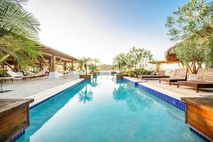 einen Pool in einem Resort mit Stühlen und Bäumen in der Unterkunft Villa #35 - Blue Venao, Playa Venao in Playa Venao