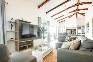 un soggiorno con divano e TV di Blue Venao PENTHOUSE APARTMENT B a Playa Venao