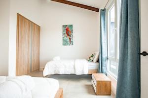 1 Schlafzimmer mit 2 Betten und einem Fenster in der Unterkunft Blue Venao PENTHOUSE APARTMENT B in Playa Venao