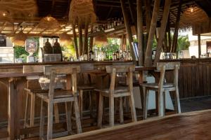 a bar with two stools at a wooden counter at Blue Venao CONDO APARTMENT D11 in Playa Venao
