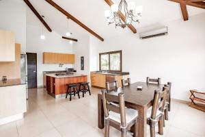 eine Küche und ein Esszimmer mit einem Holztisch und Stühlen in der Unterkunft OceanView 2 Floor Villa Private Pool Villa Larisa in Andromeda Pedasi in Pedasí Town