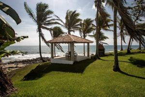 un cenador en la playa con palmeras y el océano en Super Private Beachfront 3BR Villa with Infinity Pool Andromeda Pedasi, en Pedasí Town
