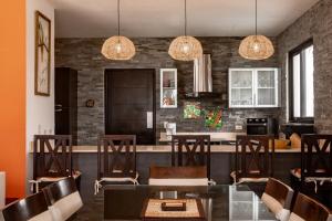cocina con mesa, sillas y luces en Super Private Beachfront 3BR Villa with Infinity Pool Andromeda Pedasi, en Pedasí Town