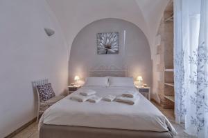 una camera con un letto bianco e due sedie di Borgo Diaz a Cisternino