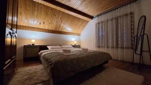 une chambre avec un grand lit avec un plafond en bois dans l'établissement Nest for rest, à Mojkovac