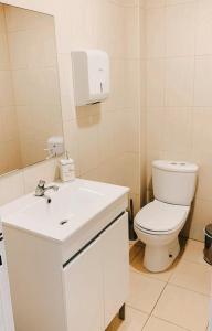a white bathroom with a toilet and a sink at Casa dos artistas in Viseu +91 photos