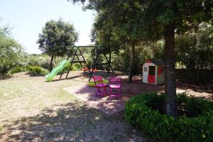 アルゲーロにあるVilla Rosannaのピンクの椅子2脚とブランコ付きの遊び場