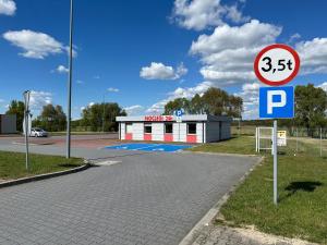 Hotel A4 Młyński Staw Autostarada A4 Opole في Rzędziwciowice: وجود لافته على الشارع امام مواقف السيارات