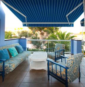 a porch with a couch and two chairs and a table at Apartamento Playa Surf by costablancarent in Denia