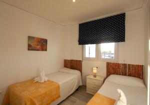 - une chambre avec 2 lits et une fenêtre dans l'établissement Apartamento Playa Surf by costablancarent, à Dénia