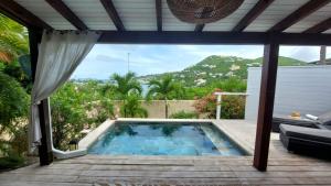 a swimming pool on a patio with a view at Romantic SWEETY COTTAGE WITH ITS PRIVATE POOL & GEORGEOUS VIEW in Saint Martin