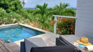 a small swimming pool sitting on a wooden deck at Romantic SWEETY COTTAGE WITH ITS PRIVATE POOL & GEORGEOUS VIEW in Saint Martin