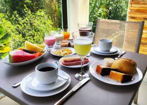 una mesa cubierta con platos de comida y bebida en ILOA J - Apartamento Família en Barra de São Miguel