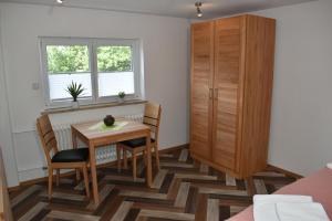 a dining room with a table and chairs and a cabinet at Ferienwohnung Am Steigerwaldrand in Sugenheim