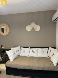 a couch with white pillows on it in a room at Coco and sun Hibiscus Le Manganao in Belle-Allée +14 photos