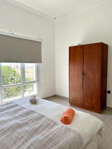 1 dormitorio con 1 cama grande y armario de madera en VILLA seeb 2 MIN walk to the beach, en Seeb