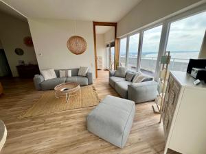 un soggiorno con divani e tavolo di COAST HOUSE Sky Suite a Bremerhaven