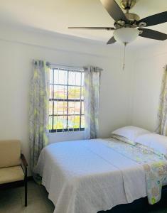 a bedroom with a bed and a ceiling fan at Oceans Rental Apartments in DʼArbeau