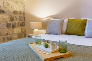 a bedroom with a bed with a tray of water and glasses at Boutique hotel Ruzmarin SPA & Garden by Aycon in Budva