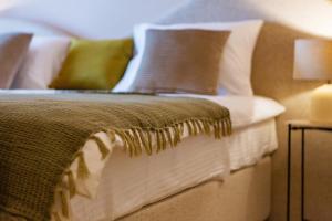 a bed with pillows and a blanket on it at Boutique hotel Ruzmarin SPA & Garden by Aycon in Budva