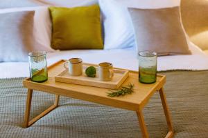 a wooden table with two glasses and a tray with drinks on it at Boutique hotel Ruzmarin SPA & Garden by Aycon in Budva +37 photos