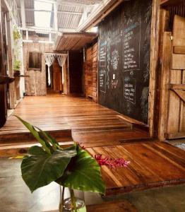 een kamer met een houten vloer en een krijtbord bij Roots Family in Puerto Viejo