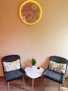 布達佩斯的住宿－Garden villa，两把椅子和一张桌子,墙上有盘子