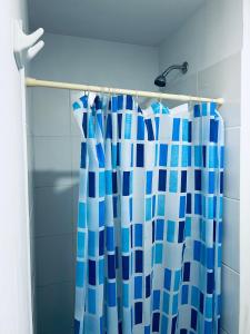 uma cortina de chuveiro azul e branco na casa de banho em Departamento en Condominio Comas em Lima
