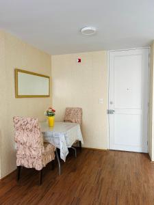 um quarto com uma mesa e duas cadeiras e uma porta em Departamento en Condominio Comas em Lima