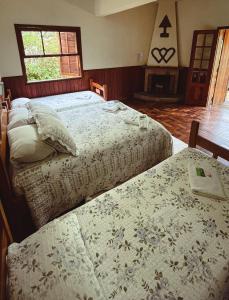 a bedroom with two beds and a window at Hotel Pião Mineiro in Monte Verde