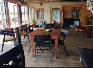 uma sala de jantar com mesas e cadeiras de madeira em Hotel Little Queen Lobster em Laguna de Perlas