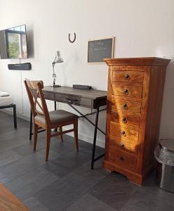 a desk and a dresser with a lamp and a chair at Privates Gästezimmer in Altenburg in Altenburg