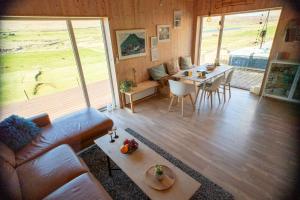 ein Wohnzimmer mit einem Sofa und einem Tisch in der Unterkunft Luxury cottage - in amazing surroundings in Sandur