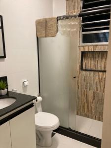 y baño blanco con aseo y ducha. en COPANEMA - Próximo Ipanema Arpoador en Río de Janeiro