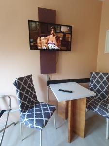 um quarto com uma mesa e duas cadeiras e uma televisão em CityPark Aparthotel em Colônia