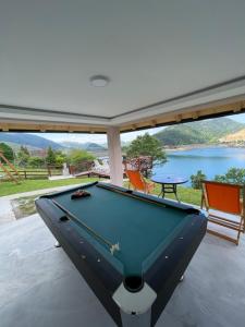 a pool table on a patio with a view of a lake at Zoranovi konaci in Jevtići