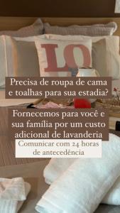 a poster for a hotel room with a bed with pillows at Flat B306 Village Aldeia das Águas in Barra do Piraí